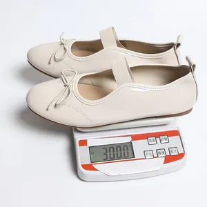 Detail view of lightweight beige patent leather ballet flats weighing 300g on a scale