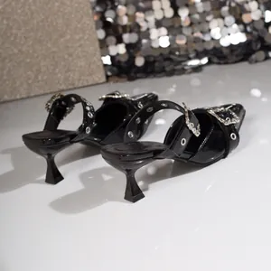 Detailansicht schwarzer Lackleder-Heels mit spitzer Zehenpartie und Strassschnallen