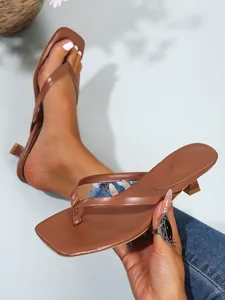 Detaillierte Nahaufnahme von eleganten braunen Zehentrenner-Sandalen mit Pfennigabsatz Design