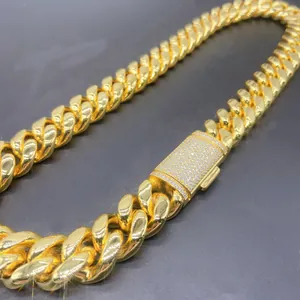 Macro detail of 18mm gold plated Cuban link chain featuring an iced out moissanite box clasp