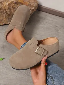 Close-up of stylish taupe suede platform mules featuring a chic metal buckle strap