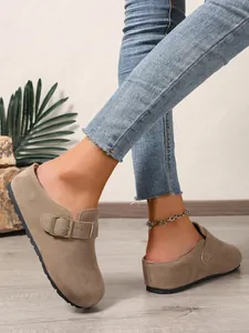 Detailed view of stylish taupe suede slip-on mules featuring an adjustable buckle strap