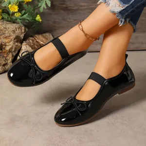Stylish black patent leather Mary Jane flats with bow detail and elastic strap