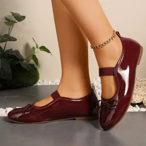 Elegant wine red patent leather Mary Jane flats featuring a bow detail and elastic strap