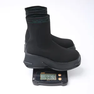 Detailed view of black chunky platform knit sock boots on a scale weighing 936.5g.