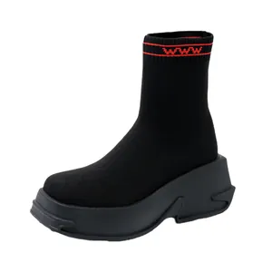 Close-up of black knitted sock boot with chunky platform sole and red accent