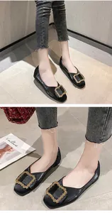 Elegant close-up of black pointed-toe flats featuring an ornate gold buckle detail
