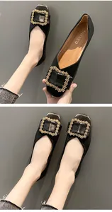 Detailed view of elegant black square-toe flats featuring a decorative gold beaded buckle