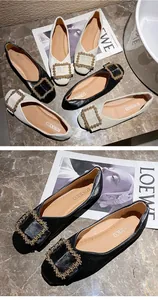 Elegant women's flat shoes featuring a decorative gold buckle on a black leather finish.