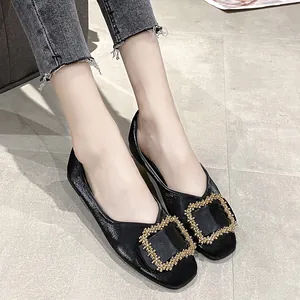 Close-up detail of black square toe flat shoes with a decorative gold beaded buckle