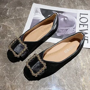 Black women's ballet flats with elegant square rhinestone buckle on marble background