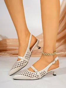 Detailansicht cremefarbener spitzer Kitten-Heels mit hohlem lasergeschnittenem Muster.