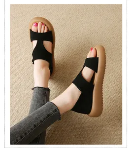 Nahaufnahme leichter schwarzer Plateausandalen mit weicher brauner Sohle am Modell