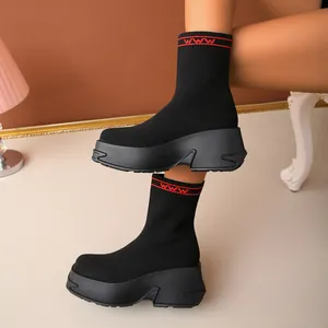 Detail of women's black fly-knit sock boots with chunky platform soles and red accents