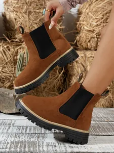 Detailed side view of brown suede Chelsea boots featuring chunky black soles and elastic panels