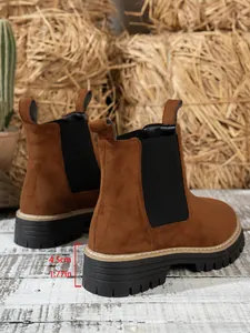Close-up of brown suede Martin boots showing the 4.5cm heel height on a thick lug sole