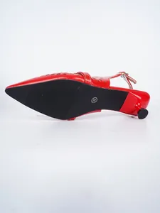 Detailansicht der schwarzen Sohle eines roten spitzen Slingback-Pumps mit Pfennigabsatz.