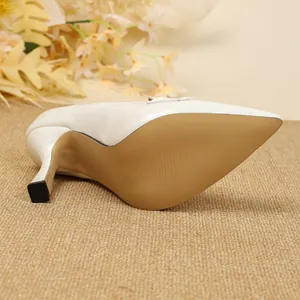 Vista detallada de zapatos de salón blancos vintage con punta fina y tacón de aguja