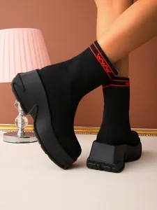 Fashionable black knit sock boots with thick platform soles and red decorative stripes