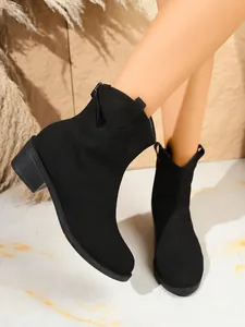 Gedetailleerde opname van zwarte suède westernboots met een halfhoge blokhak en ritssluiting.