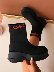 Women's black fly-knit platform sock boots with thick soles and red stripe cuff detail