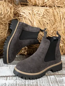 Detail view of dark grey suede Chelsea boots with platform sole and elastic side panel.