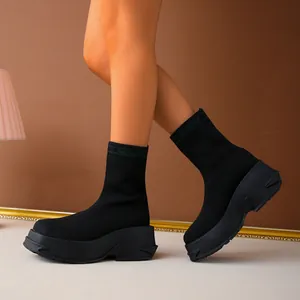 Detail of black knit sock boots with breathable fabric and chunky platform sole.