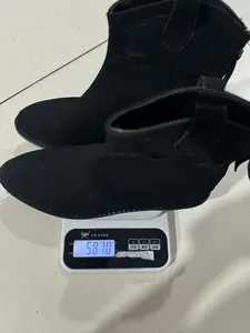 Gedetailleerd beeld van de zwarte Western enkellaarsjes op een weegschaal van 581,0 gram