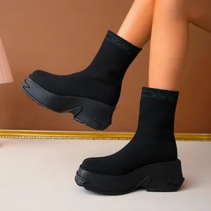 Detailed side view of stylish black platform knit sock boots with a thick wedge sole