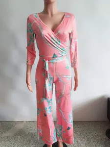 Combinaison rose élégante avec col en V et imprimé chaîne sur un mannequin de studio.