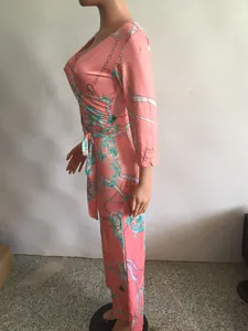 Vue latérale d'une combinaison rose à col en V avec des motifs de chaînes turquoise