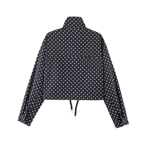 Detailansicht der Rückseite einer schwarz-weißen Punktejacke mit Stehkragen für Damen.