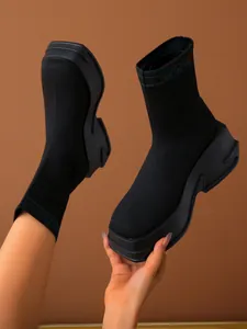 Detail view of black chunky platform knit sock boots with breathable fabric.