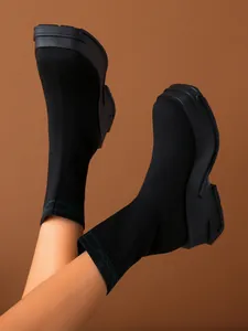 Close-up of black breathable knit sock boots with thick platform soles