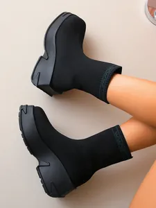 Fashionable women's black knit sock boots featuring a chunky platform sole detail view