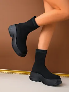Close-up detail of black platform knit sock boots featuring thick breathable chunky soles