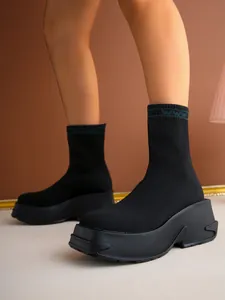 Detailed view of breathable black knit sock boots featuring a thick chunky platform sole