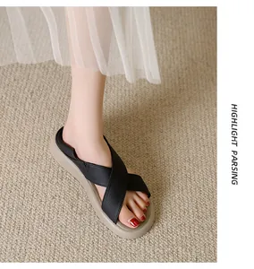 Detail of comfortable black cross strap flat sandals with beige sole