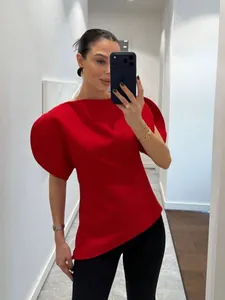 Detail of red bubble sleeve top with unique asymmetrical hem and slim fit design