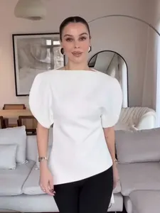Elegant white short sleeve top featuring dramatic puff sleeves and asymmetric hemline