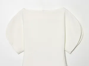 Close-up detail of a white puff sleeve slim fit top showing the boat neckline