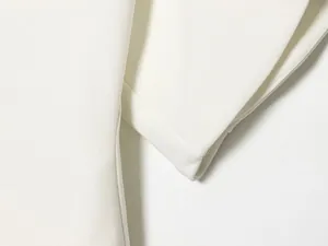 High-quality macro view of the white fabric texture and sleeve on a slim fit top
