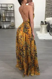 Backless detail of vibrant orange floral chiffon maxi dress with cross straps.