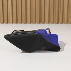 Vue détaillée de la semelle antidérapante noire et du talon compensé bleu brillant