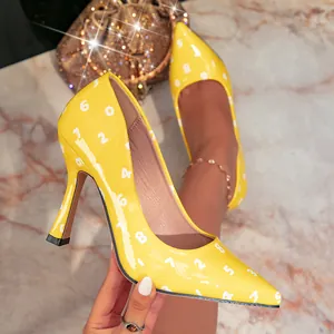 Detalle de zapatos de salón amarillos de punta con estampado numérico elegante.