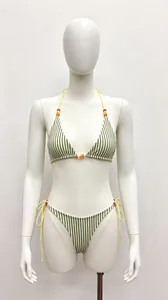 Vue détaillée d'un bikini à rayures vertes avec bretelles jaunes et perles sur un mannequin.