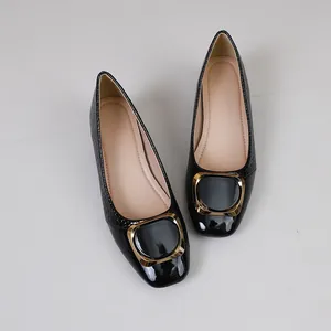 Gedetailleerd bovenaanzicht van zwarte leren werkschoenen met een elegante gouden gesp