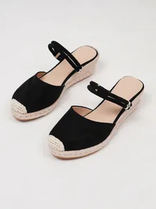 Detail van zwarte dames sleehak sandalen met een stijlvolle geweven jute touwzool