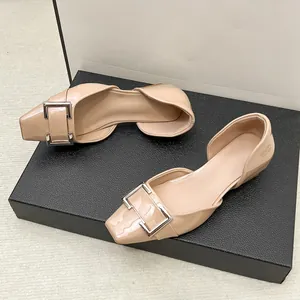 Gros plan de ballerines d'Orsay en cuir verni nude avec boucle carrée élégante.