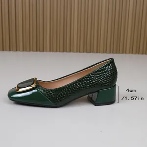 Detail van groene pumps met 4cm blokhak, vierkante neus en krokodillenpatroon